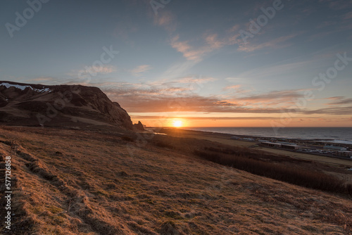 Sunset above the ocean with view on the coastine in Vík í Mýrdal, south coast of Iceland.
