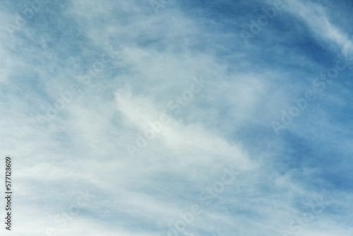 A large swirl of fluffy clouds scattered by the wind in a deep blue sky. Vector cotton texture background