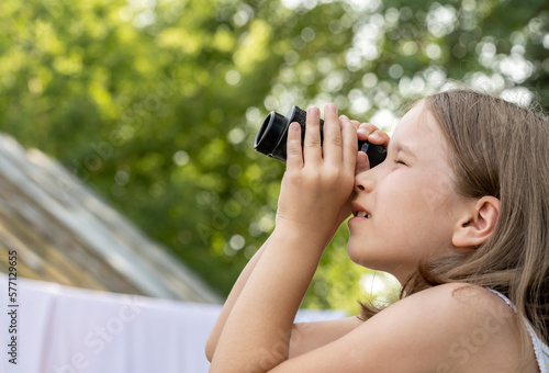 Quadro em tela Elementary school age girl looking up into the sky through a magnifying monocular glass, finding, searching for something