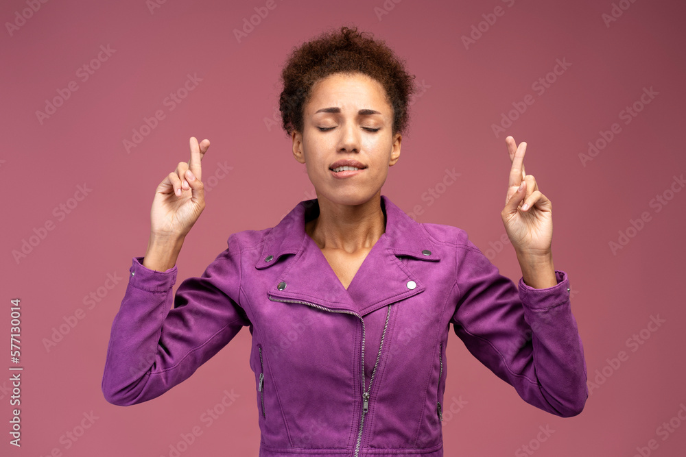Hopeful nervous brown haired woman crossing fingers for luck