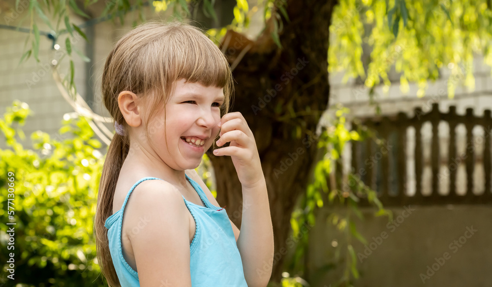 Happy young cheerful elementary school age Caucasian European child laughing outdoors, real people lifestyle, true happiness, casual shot, copy space, one person, blurred background. Summer portrait Happy young cheerful elementary school age Caucasian European child laughing outdoors, real people lifestyle, true happiness, casual shot, copy space, one person, blurred background. Summer portrait