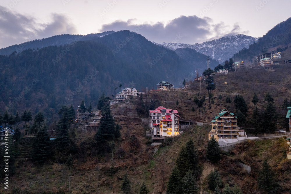 aerial drone shot of manali hill station blue hour evening with building lights at dusk showing valley with fog covered himalaya mountains showing tourist spot in himachal