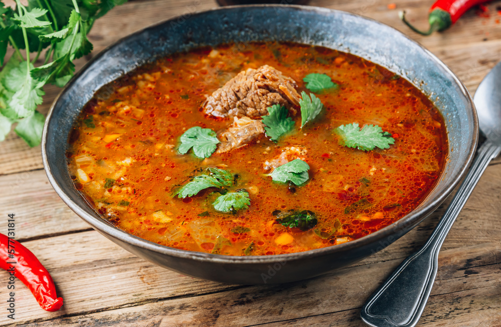 Traditional Georgian tomato soup Kharcho with beef and rice on rustic wooden background. Traditional Georgian tomato soup Kharcho with beef and rice on rustic wooden background.