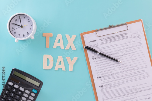 Wallpaper Mural Tax fill concept - 'Tax day' word, clock, pen and calculator  with W-8-BEN form on blue or green backgound color Torontodigital.ca