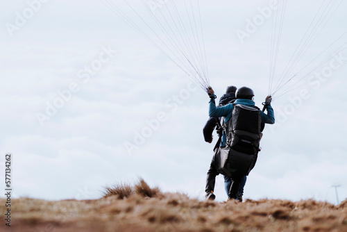 Two men take off their paragliding flight. Two men start paragliding