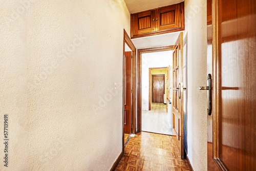 Distributor corridor of a house with glossy oak wood floors, access to other rooms with sapele wood doors and mezzanines of the same material
