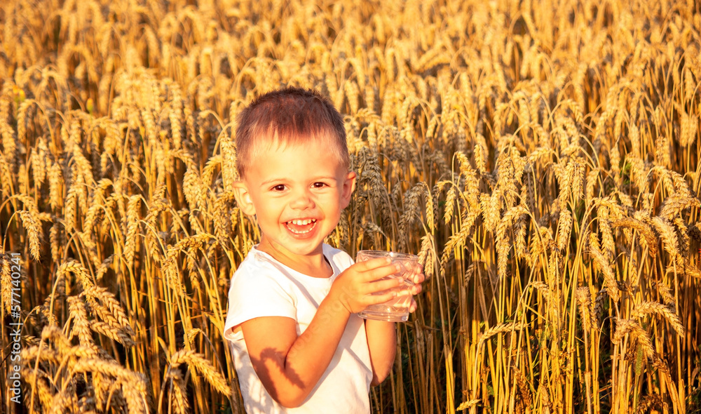 The child drinks water from a glass. Selective focus. The child drinks water from a glass. Selective focus.