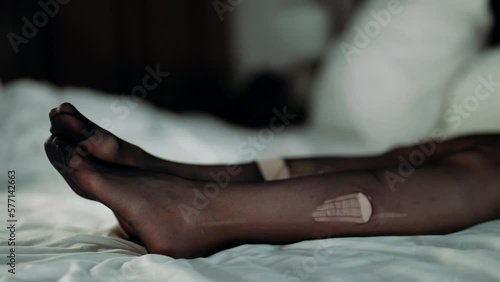 female legs in torn nylon stockings on white bed linen, prostitute in bordello after rape photo