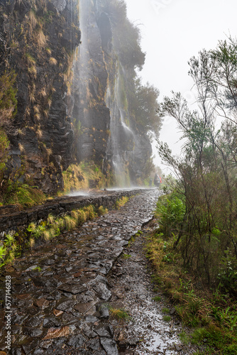 Levada da Serra hiking trail with fallinf waterfalls above Encumeada mountain pass in Madeira photo