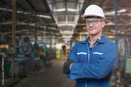 Print op canvas Portrait of manual man worker is standing with confident with blue working suite dress and safety helmet in front machine and equipment for heavy industry factory