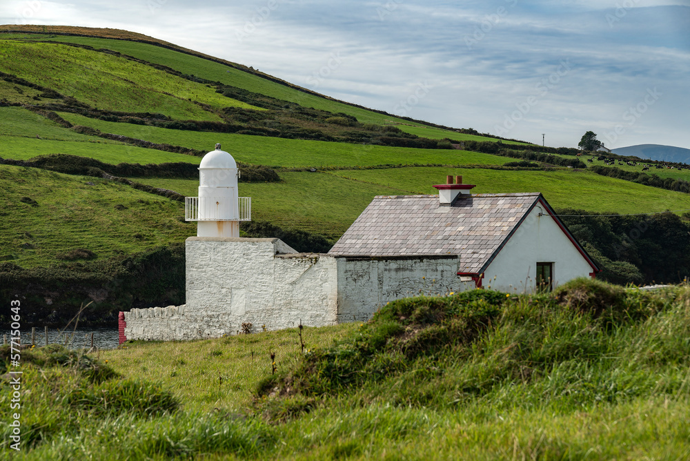 Obraz premium The bright white Dingle lighthouse surrounded by lush green meadows, Dingle Peninsula, County Kerry, Ireland