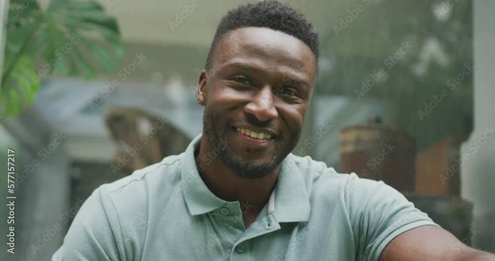 Portrait of happy african american man sitting and looking at camera in garden Portrait of happy african american man sitting and looking at camera in garden