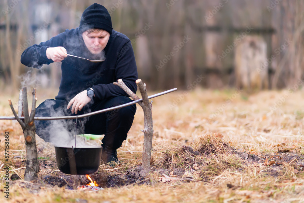 Guy blowing on a spoon to taste cooked food