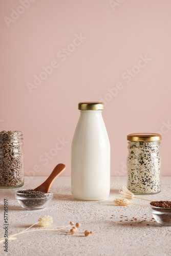 seed milk in bottle on beige background with chia, flax, sunflower, sesame seed. Raw diet meal. Healthy vegetarian food and lifestyle. eco friendly