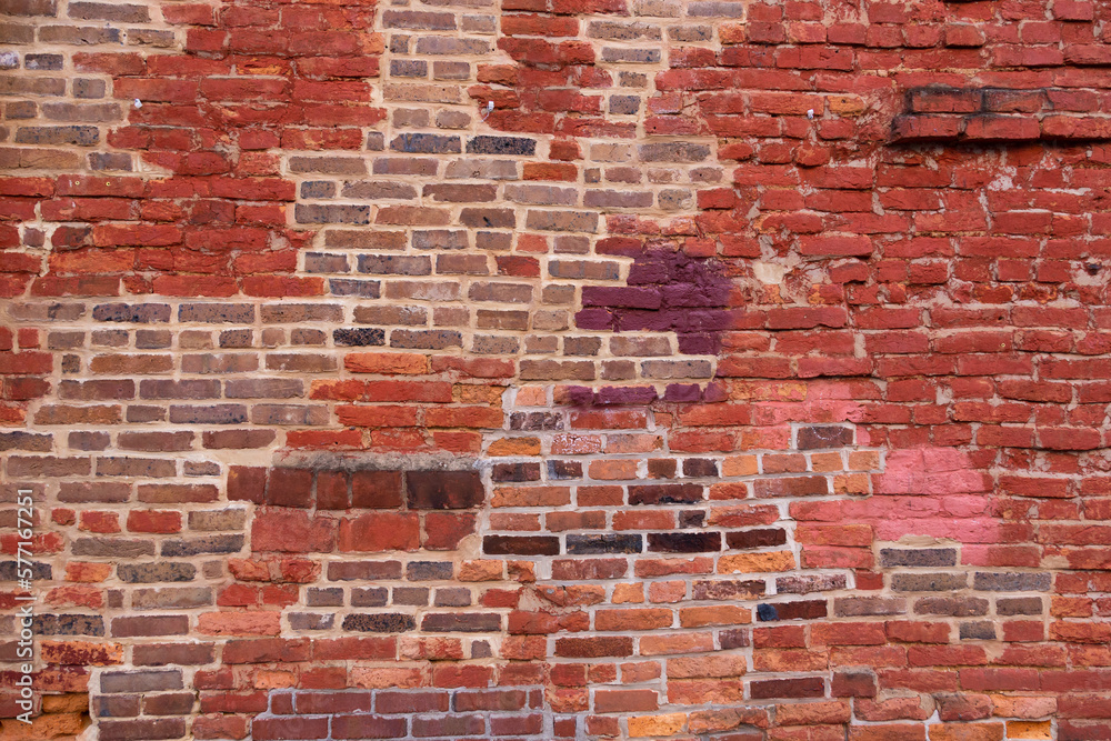 Fototapeta premium Horizontal view of old wall with patches of different coloured bricks in irregular pattern