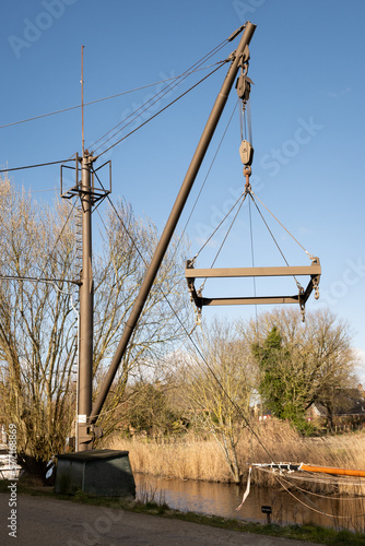 Travel lift or boat hoist on a canal side in rural countryside town Warfhuizen Groningen Netherlands on a sunny day. Dutch gantry crane used in Holland to lift boats out of the water for maintenance.