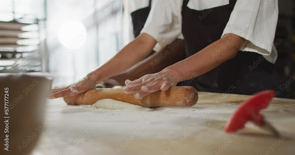 Animation of hands of asian female baker rolling sourdough for bread Animation of hands of asian female baker rolling sourdough for bread