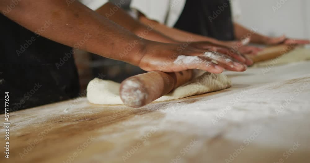 Animation of hands of diverse female and male bakers rolling sourdough for bread Animation of hands of diverse female and male bakers rolling sourdough for bread