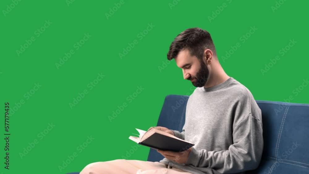 Confident man reading book literature relaxing on couch at home isolated green screen chroma key Confident man reading book literature relaxing on couch at home isolated green screen chroma key