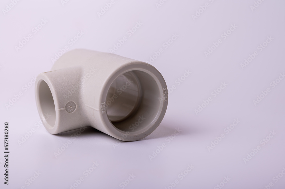 light PVC pipe tee connection for water isolated on light background close up. light PVC pipe tee connection for water isolated on light background close up.