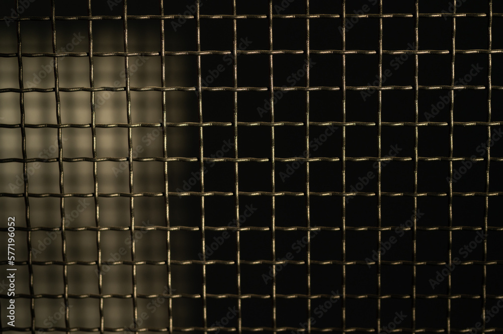 Black metal mesh on a dark background Black metal mesh on a dark background