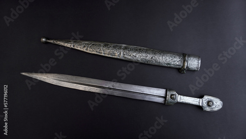 Fotografiet antique, silver dagger with scabbard on a black background.