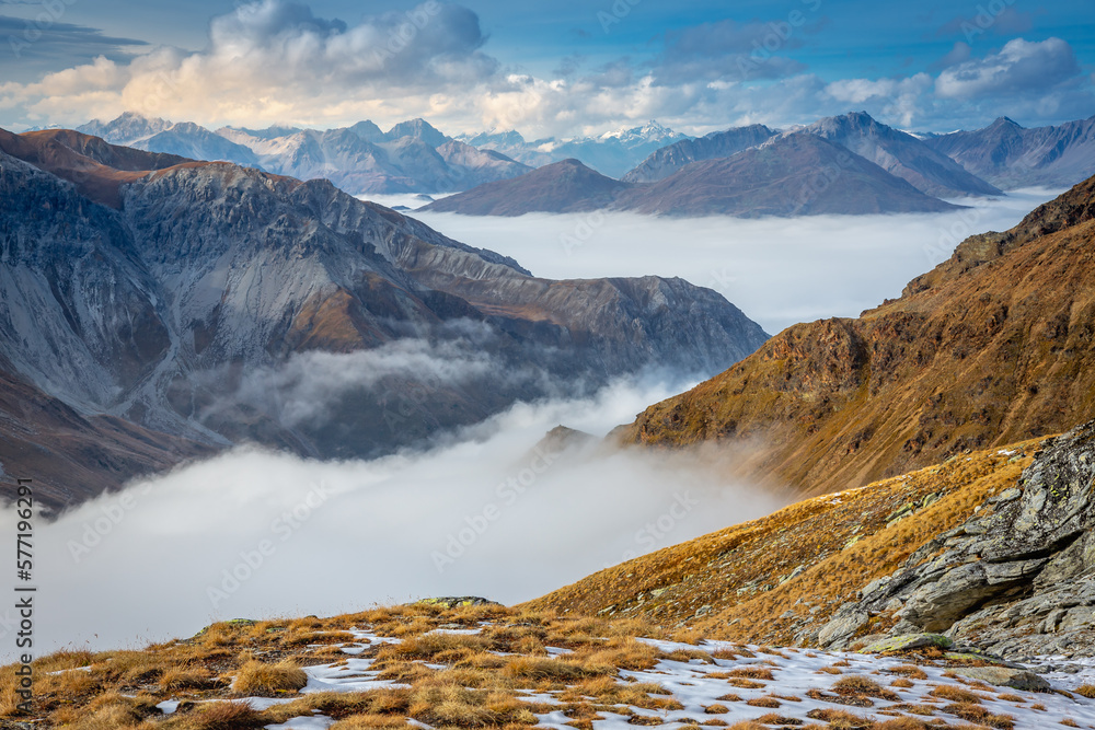 Stelvio pass, mountain dramatic landscape at dawn above mist, Italy