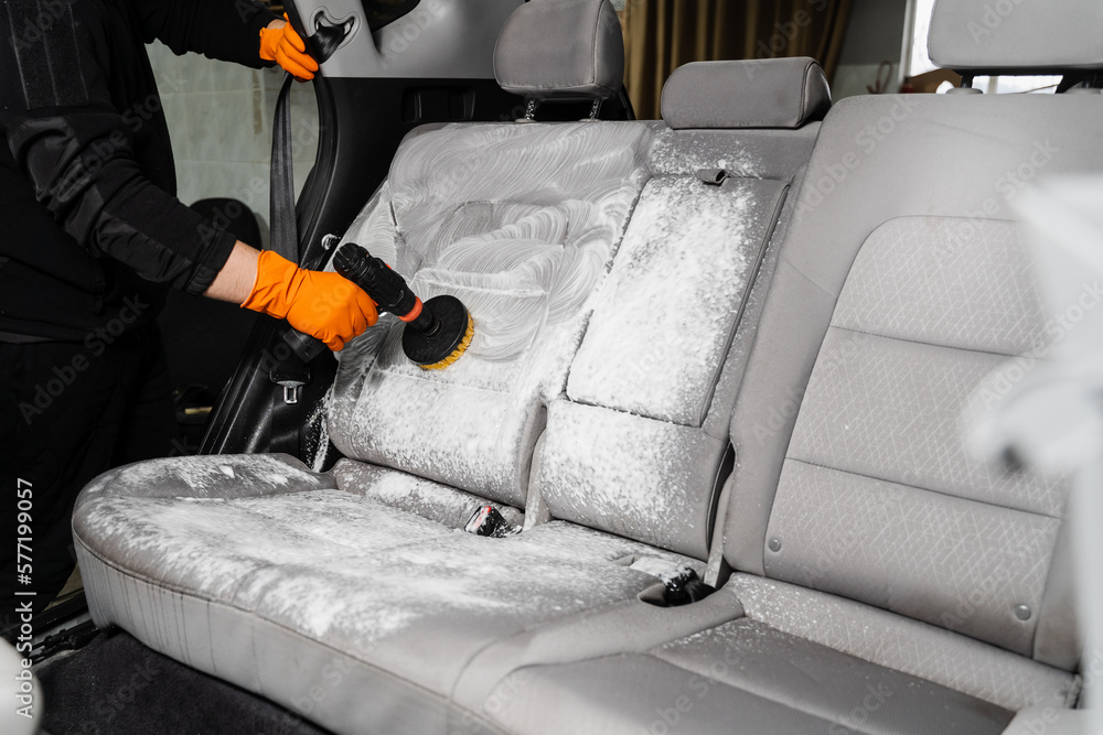 Foto de Smearing detergent on car textile seats using drill with brush