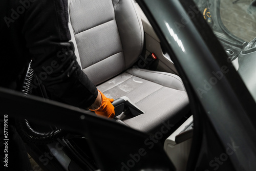 Process of extraction dirt from textile car seat using extractor cleaning machine. Dry wash cleaner is removing dirt and dust from car seat using dry cleaning extraction machine.