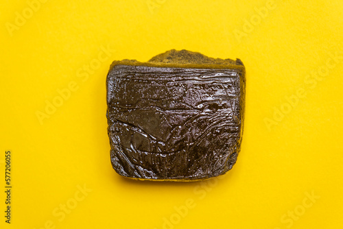 Super dry hash, medical marijuana extraction high quality fresh hashish cannabis pollen with oil on a yellow background.