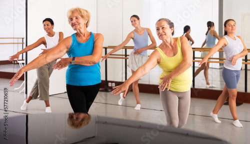 Group of active women practicing energetic dance in a modern dance studio