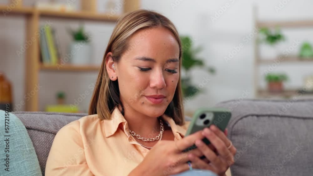 Asian woman, phone and smile relaxing on sofa for social media, chatting or texting in living room at home. Happy female smiling and typing on smartphone for chat, browsing or mobile app on the couch Asian woman, phone and smile relaxing on sofa for social media, chatting or texting in living room at home. Happy female smiling and typing on smartphone for chat, browsing or mobile app on the couch
