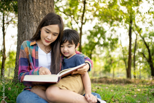 Happy Asian mother having reading with her son outdoors - Family and love concept. Mother’s day celebration.