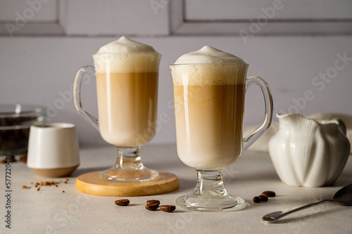 Two cups with coffee drink, latte or mocha with milk foam and cinnamon