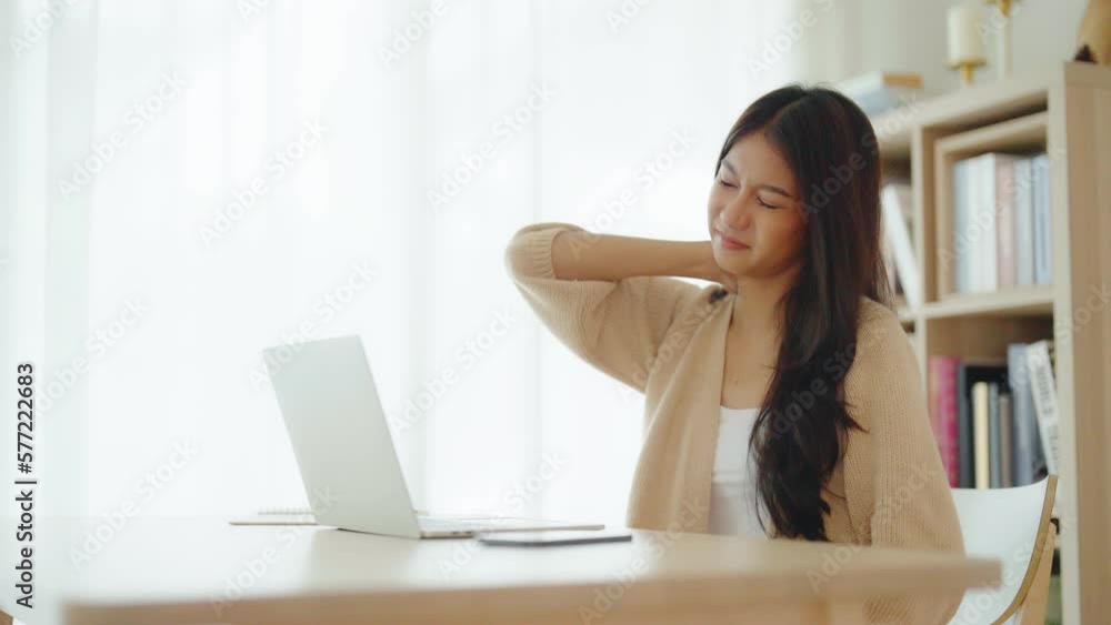 Office syndrome concept. Young asian woman feeling pain in neck and shoulder after working on computer laptop for a long time. She stretches to relax her muscles Office syndrome concept. Young asian woman feeling pain in neck and shoulder after working on computer laptop for a long time. She stretches to relax her muscles