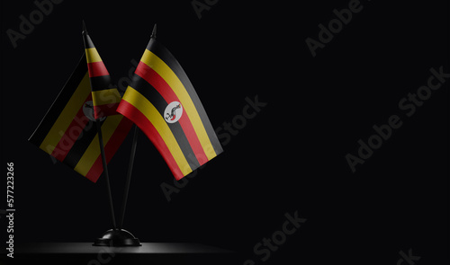 Small national flags of the Uganda on a black background