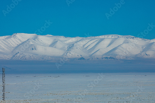 View from Chui steppe to South Chui ridge in winter day. Russia South Of Western Siberia, Altai Mountains. Desert mountains covered with snow near village of Kosh-Agach photo