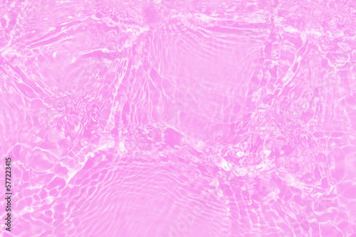 Defocus blurred transparent pink colored clear calm water surface texture with splashes and bubbles. Trendy abstract nature background. Water waves in sunlight with copy space. Purple watercolor shine
