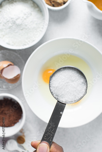 White sugar in a measuring cup, sugar for baking in a cup