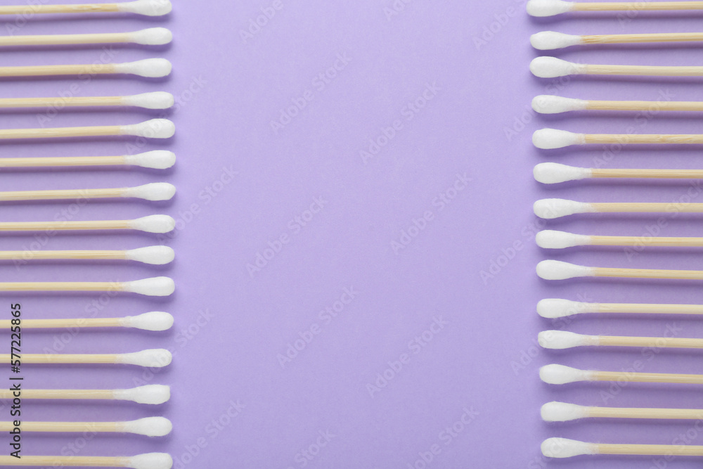 Many wooden cotton buds on violet background, flat lay. Space for text Many wooden cotton buds on violet background, flat lay. Space for text