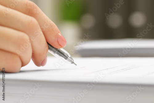 Woman signing document, closeup view. Space for text