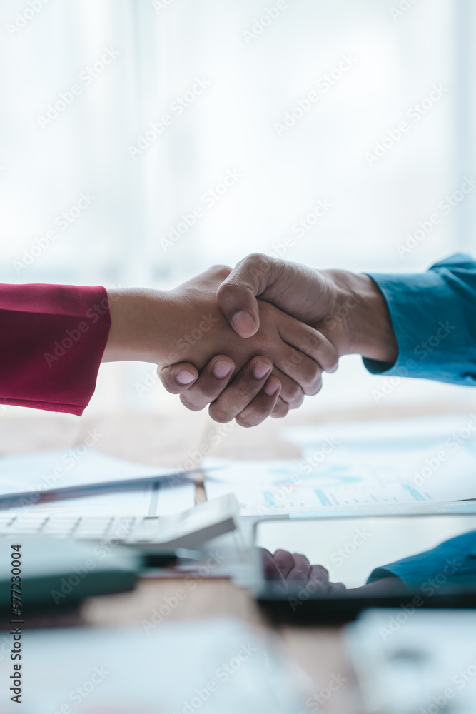 Close up bookkeepers working with balance sheet to analyze problems and find solutions to bringing develop business organization and company's stock market system. Shaking hands after agreement - obrazy, fototapety, plakaty 
