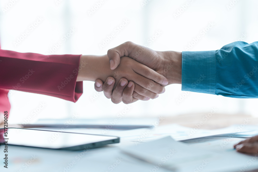 Close up bookkeepers working with balance sheet to analyze problems and find solutions to bringing develop business organization and company's stock market system. Shaking hands after agreement Close up bookkeepers working with balance sheet to analyze problems and find solutions to bringing develop business organization and company's stock market system. Shaking hands after agreement