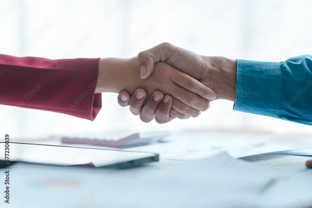Close up bookkeepers working with balance sheet to analyze problems and find solutions to bringing develop business organization and company's stock market system. Shaking hands after agreement Close up bookkeepers working with balance sheet to analyze problems and find solutions to bringing develop business organization and company's stock market system. Shaking hands after agreement