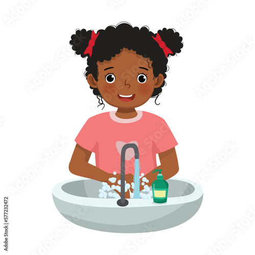 Cute little African girl washing hands with antibacterial soap and running water at the sink as prevention against Virus and Infection