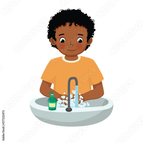 Cute little African boy washing hands with antibacterial soap and running water at the sink as prevention against Virus and Infection