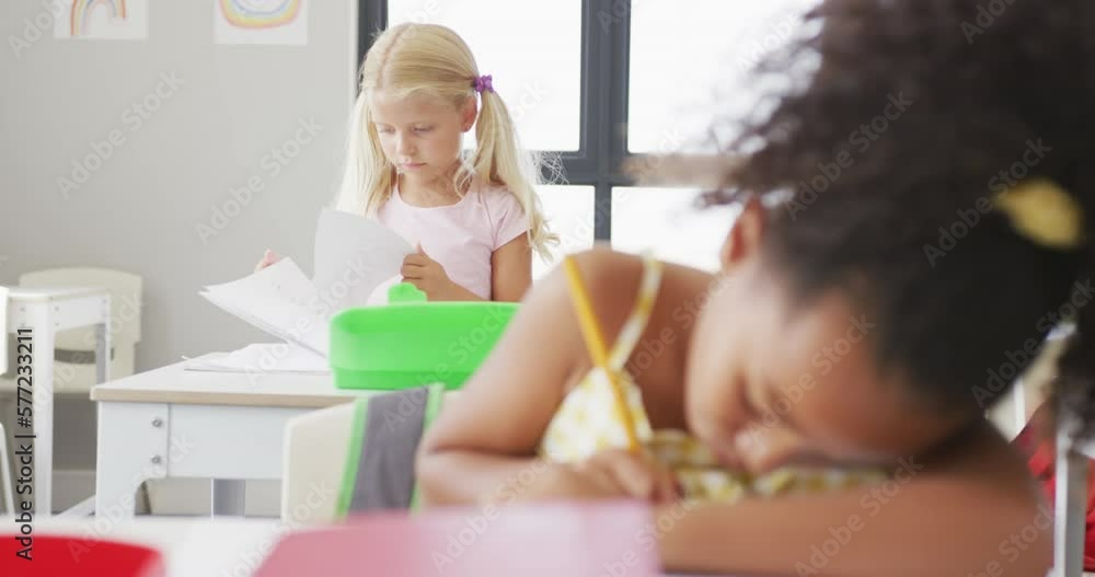 Video of focused diverse girls sitting at school desks and learning Video of focused diverse girls sitting at school desks and learning