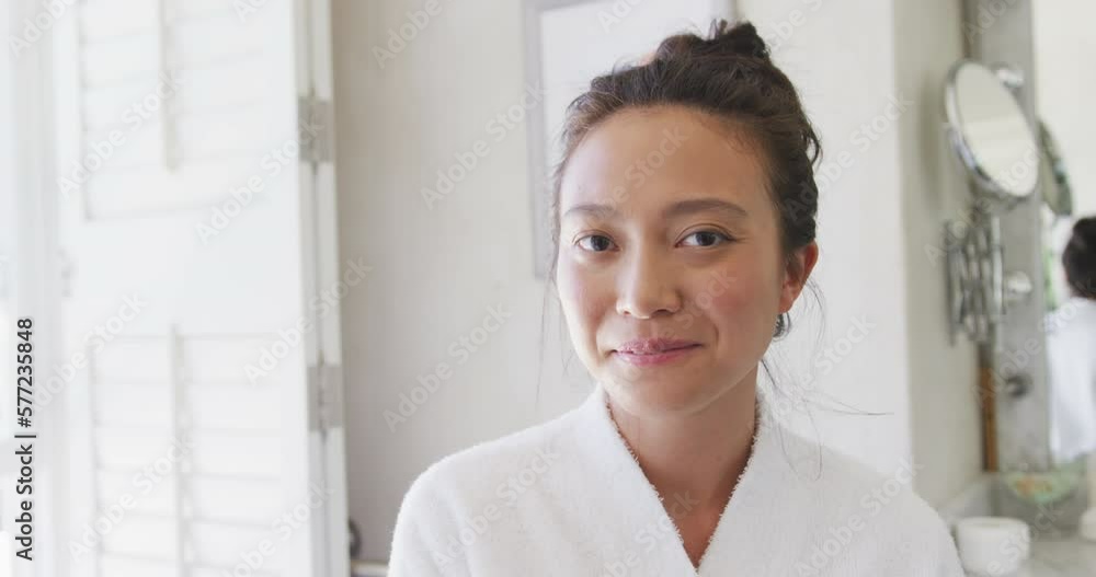 Portrait of happy asian woman smiling in bathroom, in slow motion Portrait of happy asian woman smiling in bathroom, in slow motion