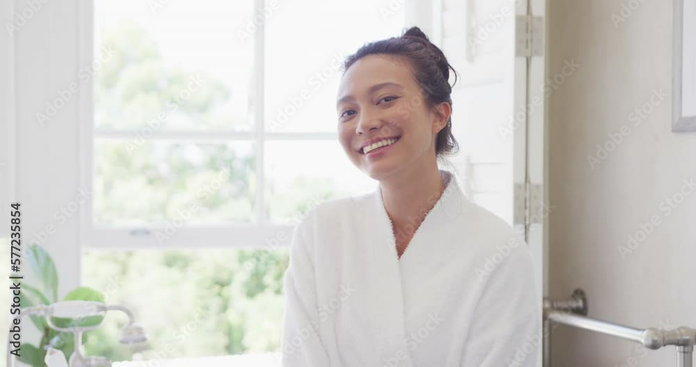Portrait of happy asian woman smiling in bathroom, in slow motion Portrait of happy asian woman smiling in bathroom, in slow motion