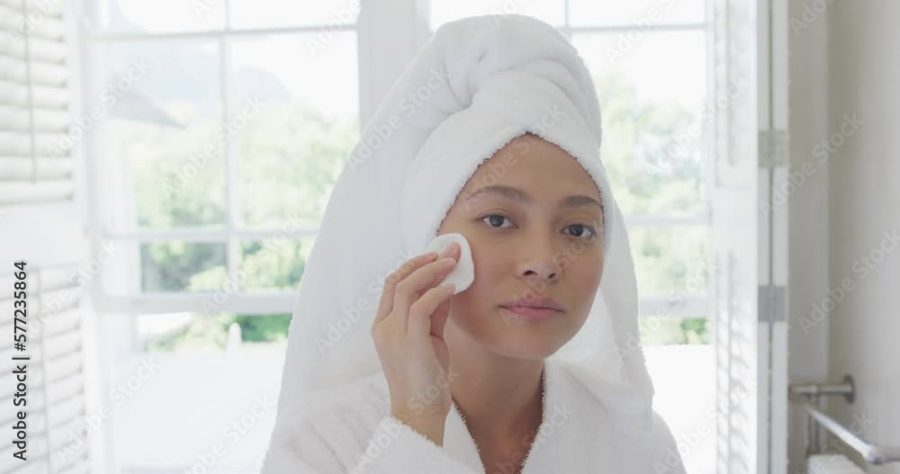 Happy asian woman cleansing skin in bathroom, in slow motion Happy asian woman cleansing skin in bathroom, in slow motion